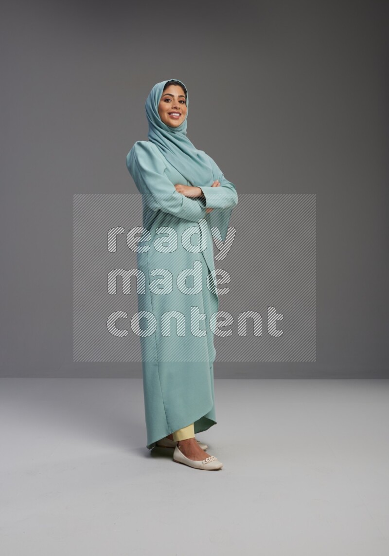 Saudi Woman wearing Abaya standing with crossed arms on Gray background