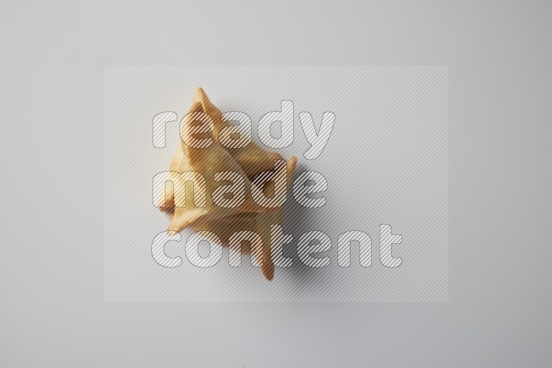 Three fried sambosa from a top angle on a white background
