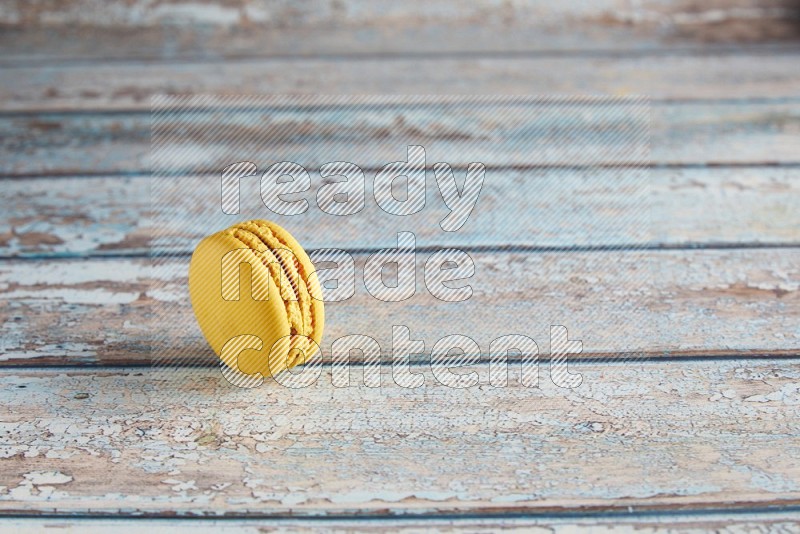 45º Shot of Yellow Lemon macaron on light blue wooden background