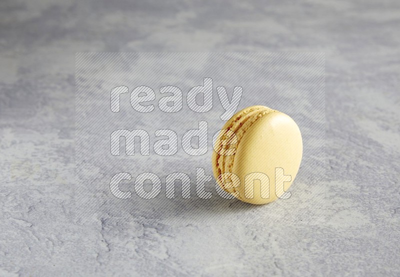 45º Shot of Yellow Vanilla macaron on white  marble background