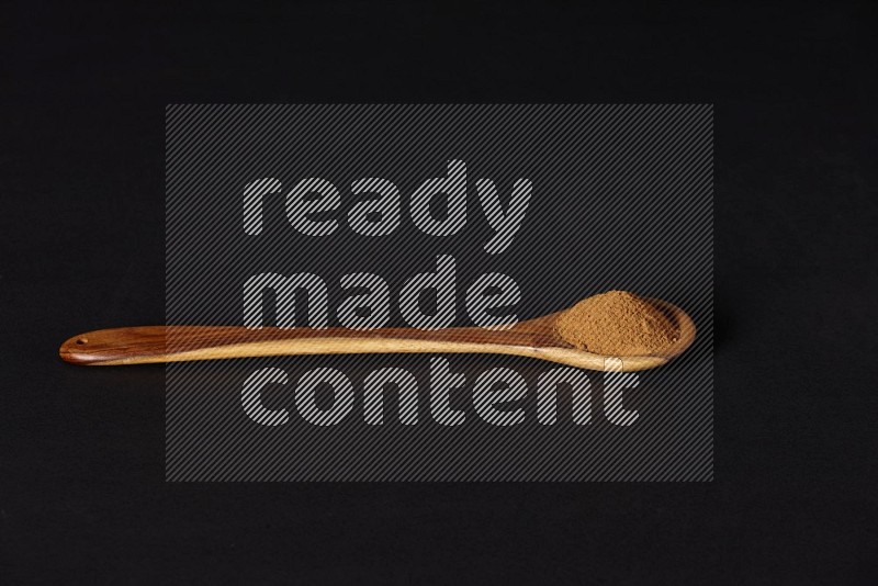 Cinnamon powder in a wooden ladle spoon on black background in different angles