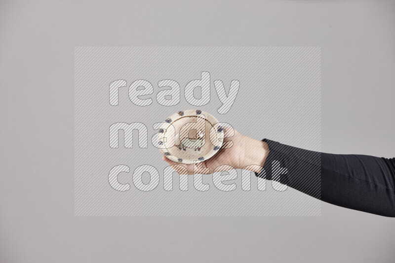 A woman in black abaya holding different pottery essentials in different positions