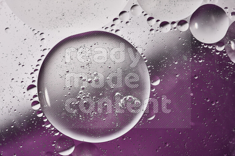 Close-ups of abstract oil bubbles on water surface in shades of white and purple