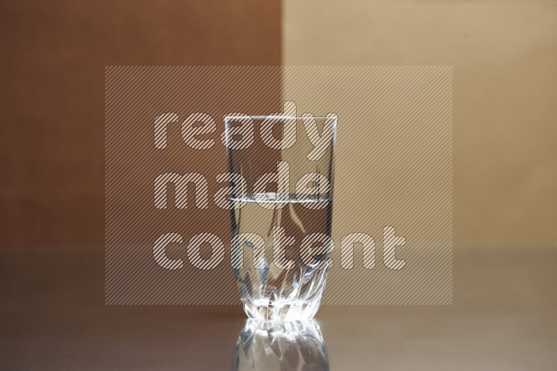 The image features a clear glassware filled with water, set against brown and light brown background