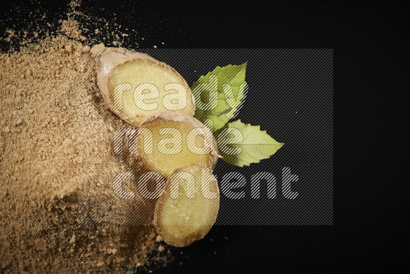 A bunch of ground ginger powder on black background