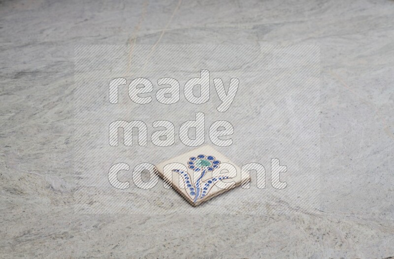 Top view shot of a pottery coaster\ tile on beige marble flooring