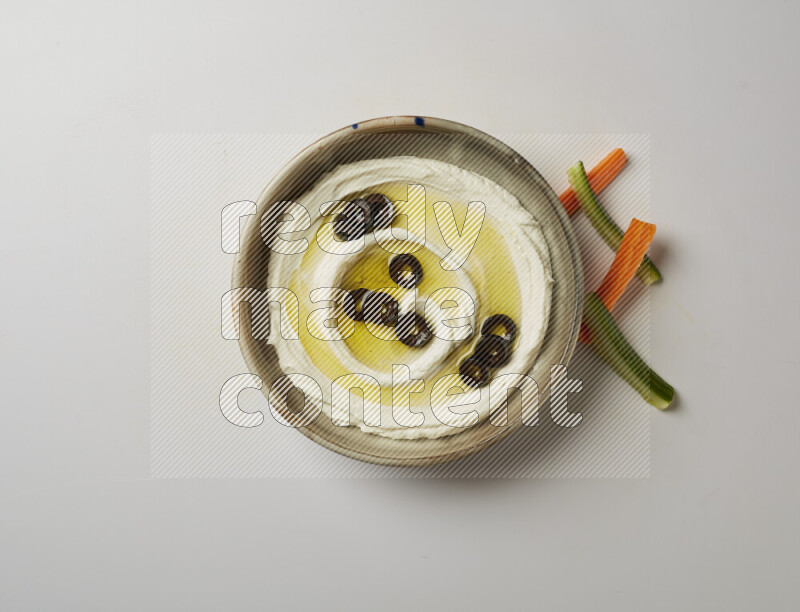 Lebnah garnished with sliced olives in a grey pottery plate on a white background
