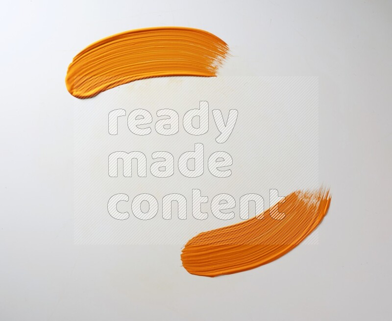 An orange curved painting brush stroke on a white background