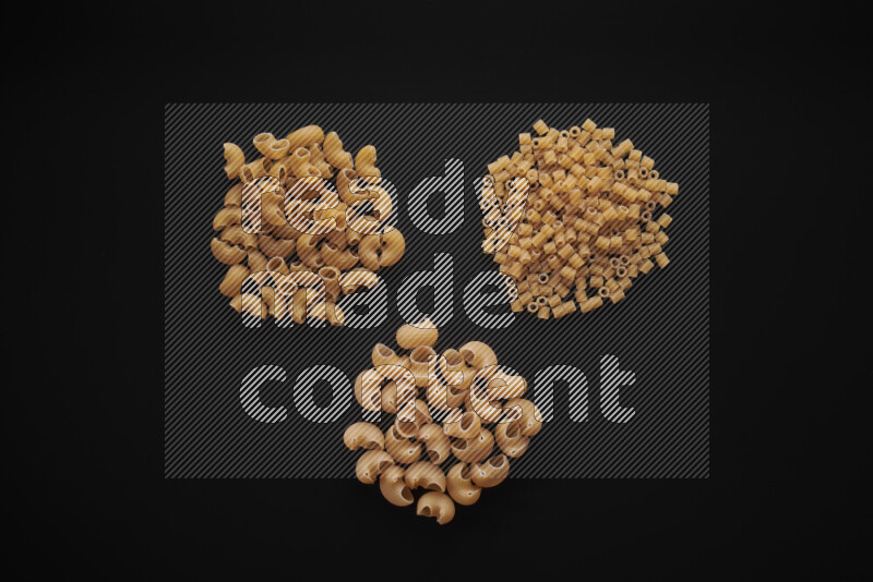 Different pasta types in bunches on black background