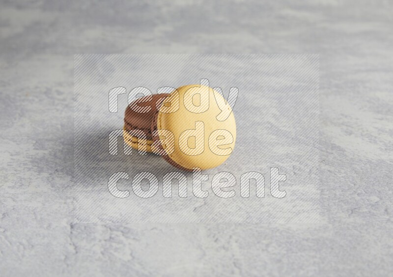 45º Shot of two Yellow and Brown Chai Latte macarons r on white  marble background
