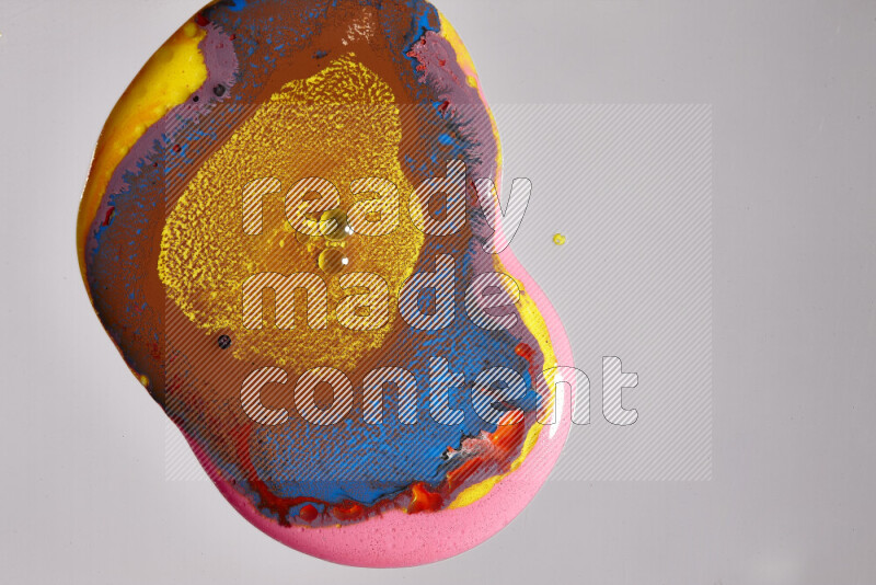 لقطات مقربة لألوان متنوعة تمتزج على خلفية رمادية