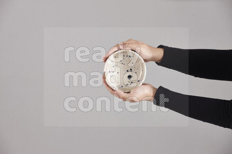 امرأة ترتدي عباءة سوداء تحمل أدوات فخارية مختلفة في أوضاع متعددة