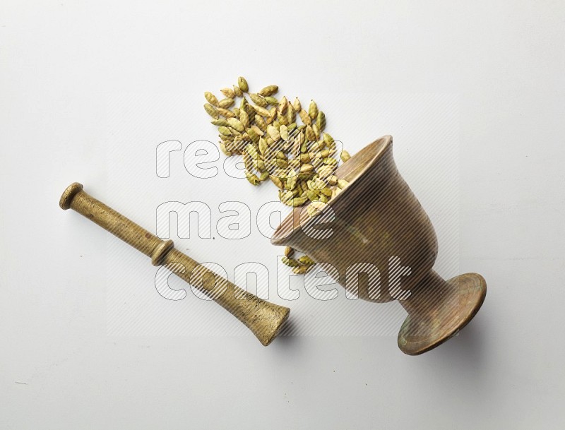 Top-view shot of Cardamon in herbs crusher on white background