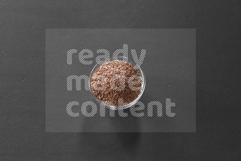 حبوب الكتان في وعاء زجاجي علي خلفية سوداء
