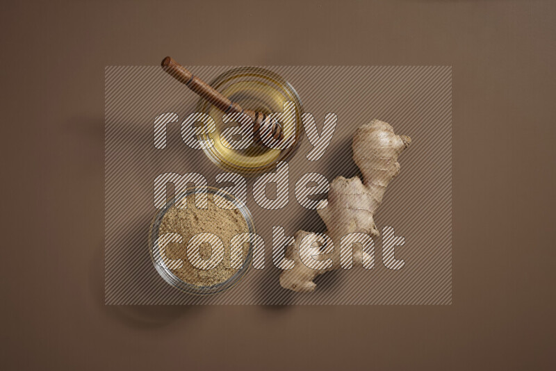 Fresh ginger root with different ingredients such as lemon, orange, honey, ground ginger on beige baackground