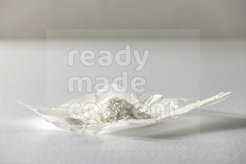 Desiccated coconut on a piece of paper on a white background in different angles