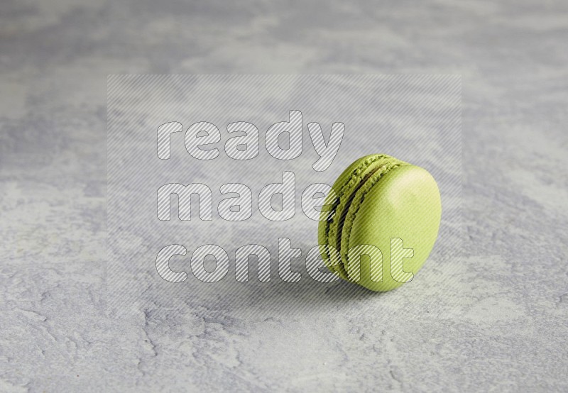 45º Shot of Yellow Lime macaron on white  marble background