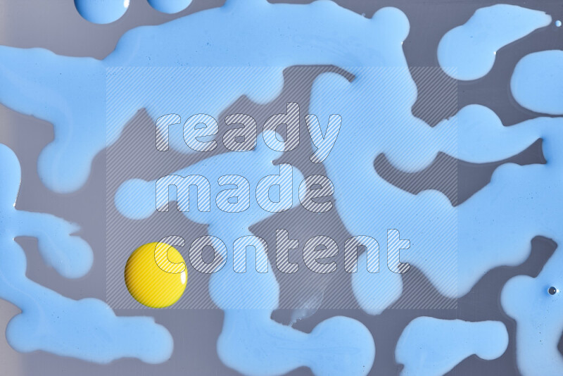 Close-ups of abstract blue and yellow paint droplets on the surface