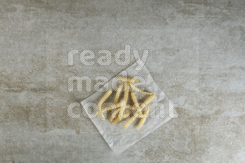 crinkle fries on parchment paper on grey textured counter top