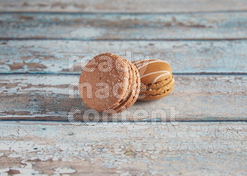 45º Shot of of two assorted Brown Irish Cream, and Brown Hazelnuts macarons  on light blue background