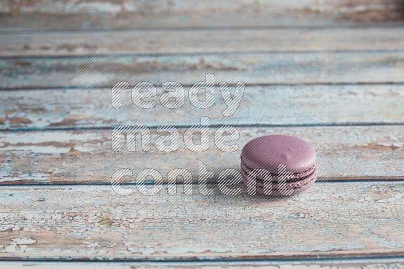 45º Shot of Purple Blueberry macaron on light blue wooden background