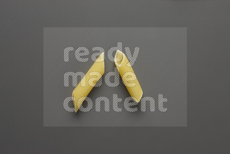 Penne pasta on grey background