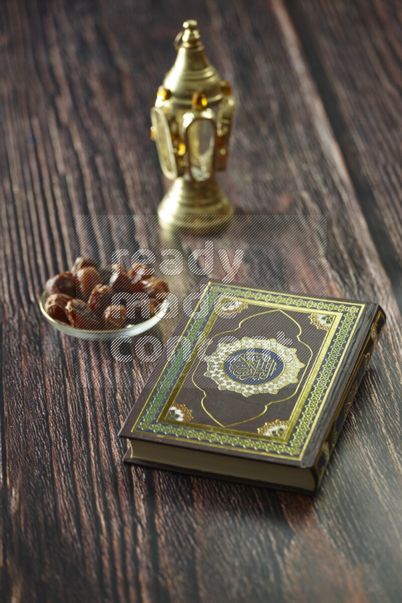 A golden lantern with different drinks, dates, nuts, prayer beads and quran on brown wooden background