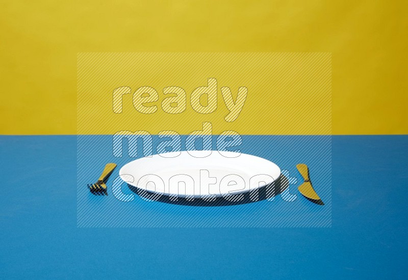 white plate and silverware on yellow and blue background