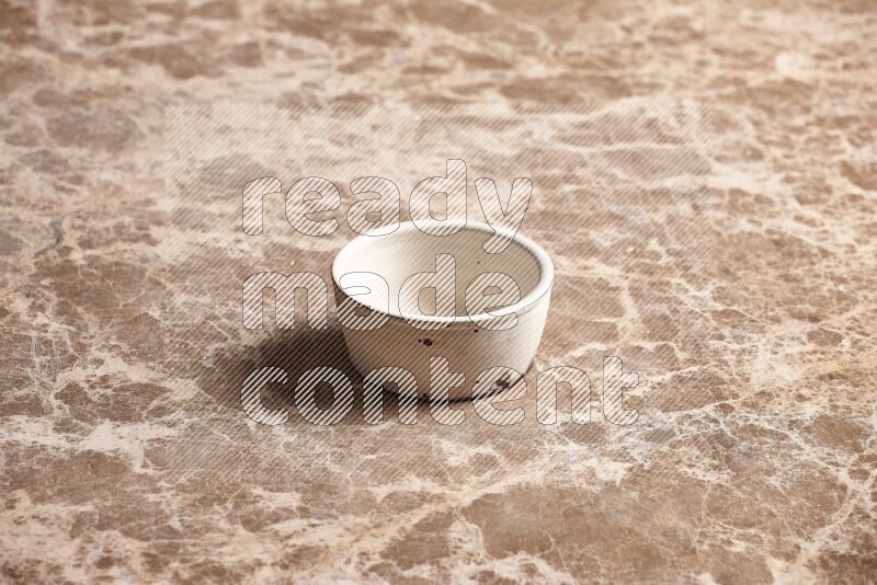 A white pottery bowl on beige marble background
