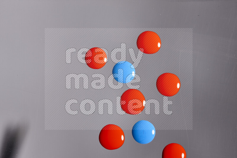 Close-ups of abstract red and blue paint droplets on the surface