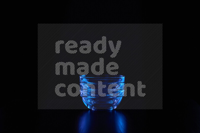 Glassware with rim light in blue against black background