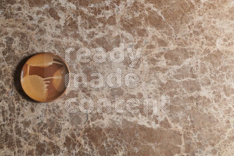 A multicolored pottery plate on beige marble background
