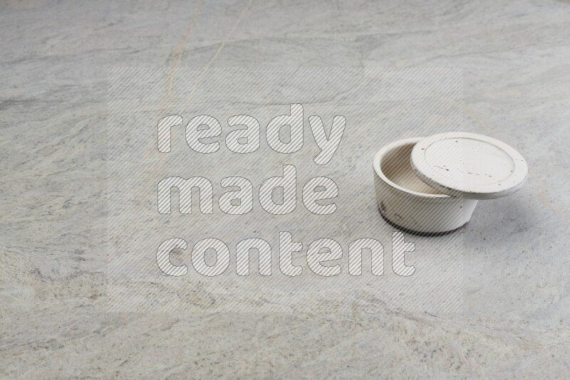 A white pottery bowl on grey marble background