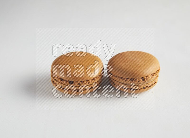 45º Shot of two Brown Maple Taffy macarons on white background