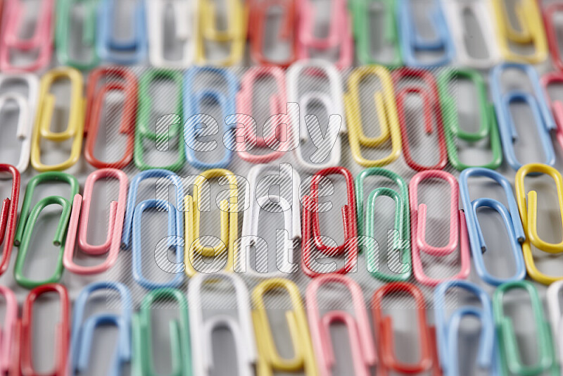 Multicolored paperclips isolated on a grey background