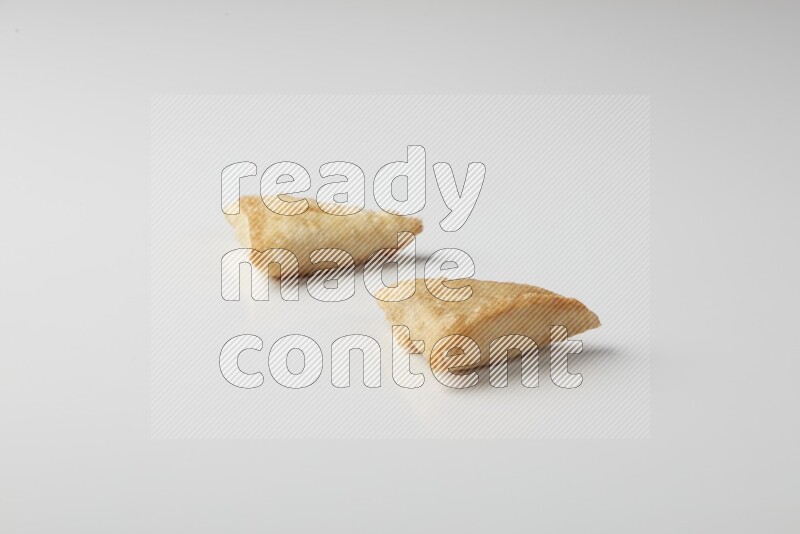 Two fried sambosas on a white background