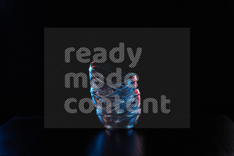 Glassware with rim light in red and blue against black background