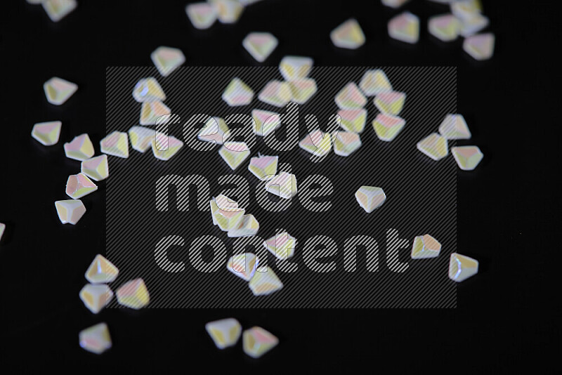 Colorful plastic shards for decoration scattered on a black background