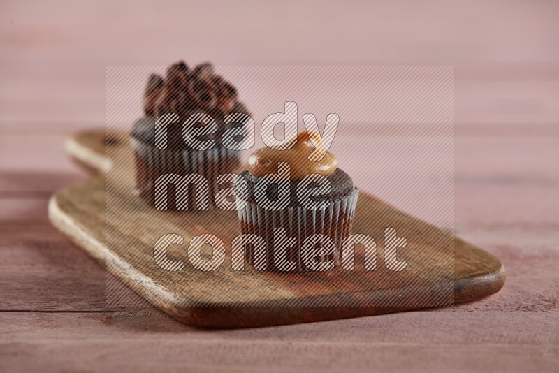 Chocolate mini cupcake topped with peanut butter on a wooden board