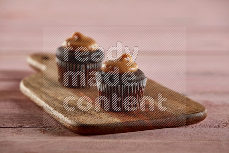Chocolate mini cupcake topped with peanut butter on a wooden board