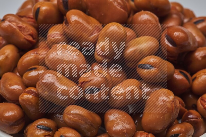 Close up shot of cooked fava beans (foul) on white background