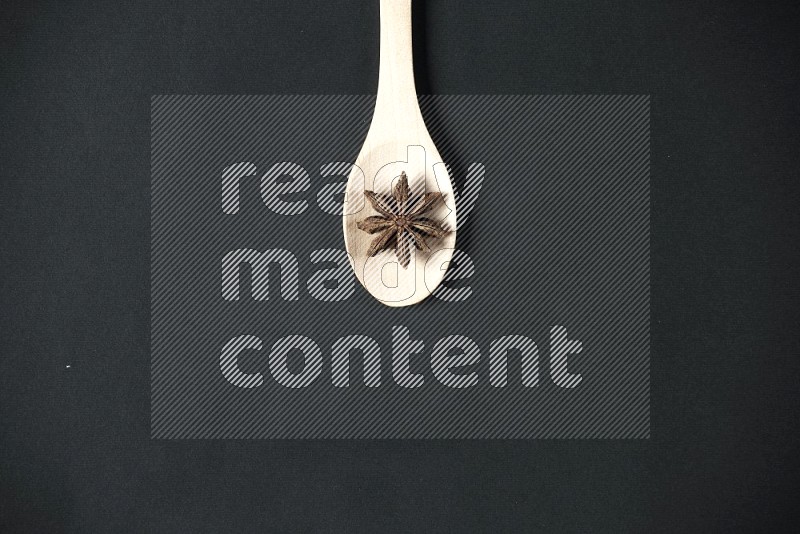 Star Anise herbs in a wooden spoon in different lighting setups and angles on black flooring