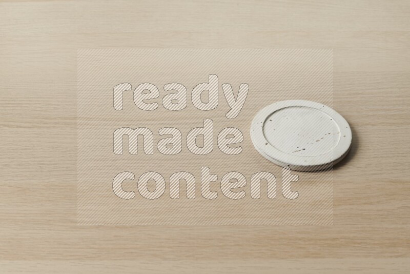 A pottery coaster on light wooden background