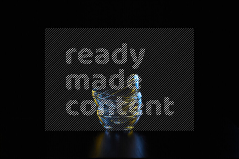 Glassware with rim light in blue and yellow against black background