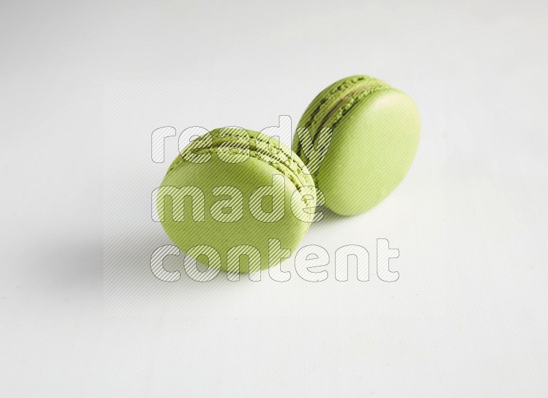 45º Shot of two Green Pistachio macarons on white background