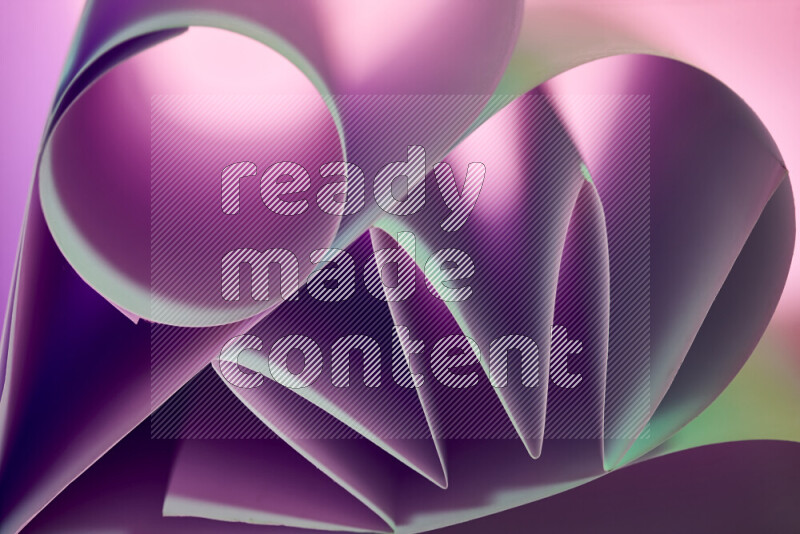 عرض فني لطيات الورق تخلق مزيج من الأشكال الهندسية، مضاءة بإضاءة ناعمة بدرجات اللون الأخضر والارجواني