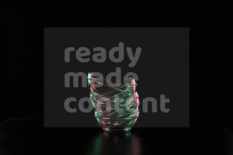 Glassware with rim light in red and green against black background