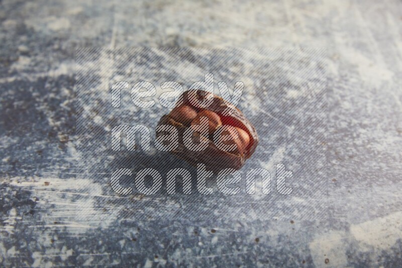 hazelnuts stuffed majdoul date on a rustic blue background