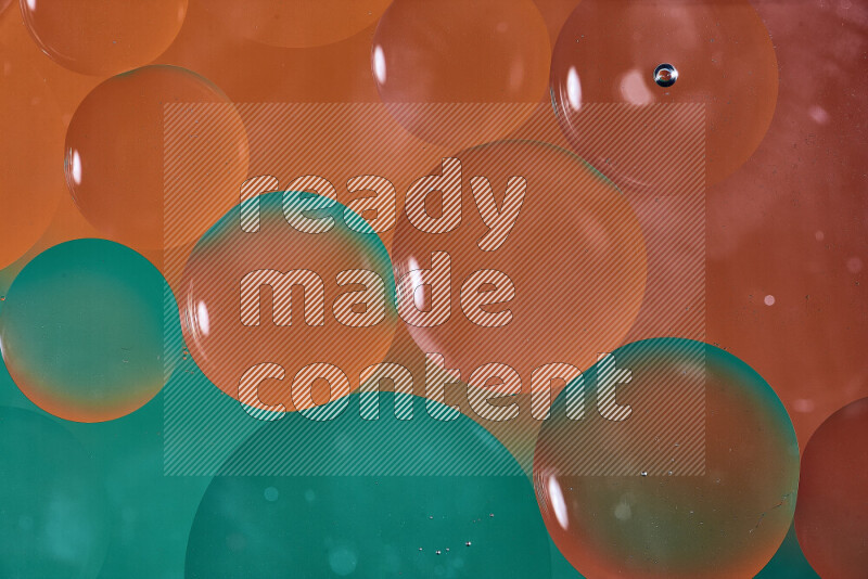 لقطات مقربة لفقاعات من الزيت على سطح الماء باللون الأخضر والبرتقالي