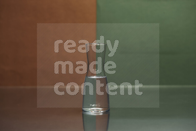 تظهر الصورة أواني زجاجية ممتلئة بالماء موضوعة على خلفية من اللونين البني والأخضر الغامق